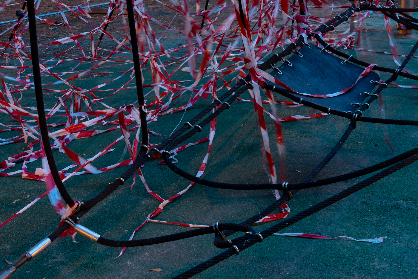 Red-white striped vinyl safety tapes amongst the ropes of climbing sphere,Trampoline park in Bikas Park, 2020. March 16 - May 18. 11th district of Budapest, Hungary. / Bikás Trambulinpark, Budapest